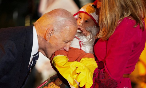 Joe Biden playfully nibbles on babies during a Halloween celebration at the White House.